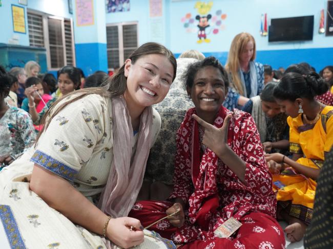 gabi sitting with a girl from a home of hope in India