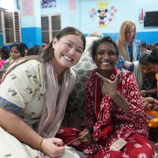 gabi sitting with a girl from a home of hope in India